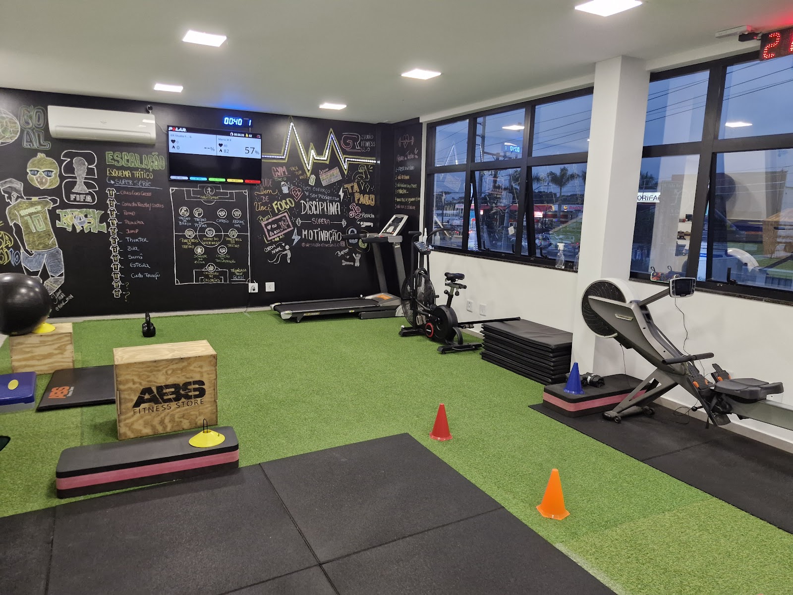 Área de treino funcional do GR Studio Fitness 2.0, com esteira, bike e quadro de treino na parede