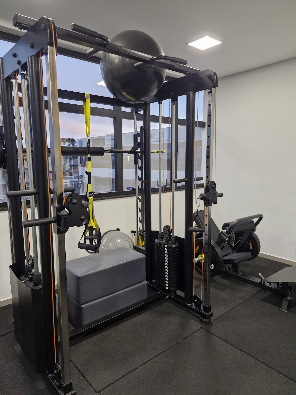 Equipamento de treino funcional com anilhas e faixas de suspensão